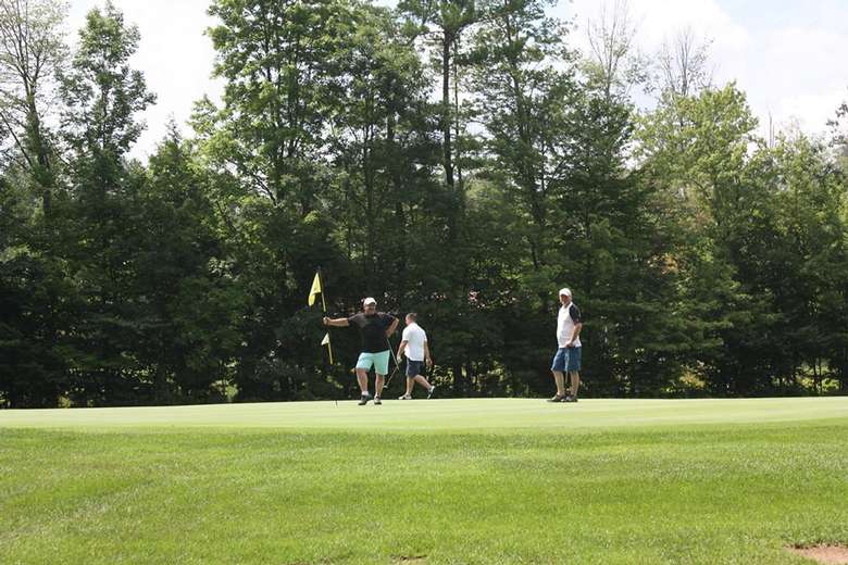 three golfers on the green