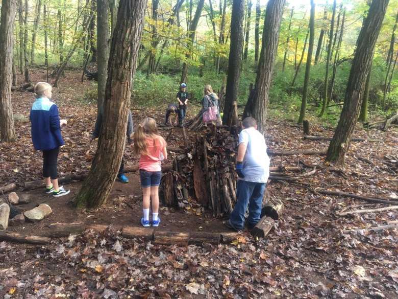 kids making a small structure in the woods