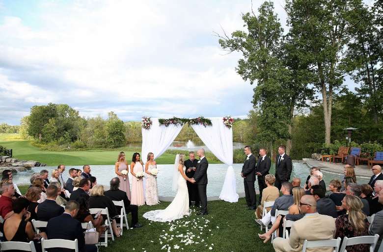 a couple saying their vows in front of guests on the golf course