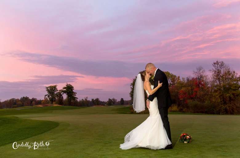 a bride and groom kissing at sunset