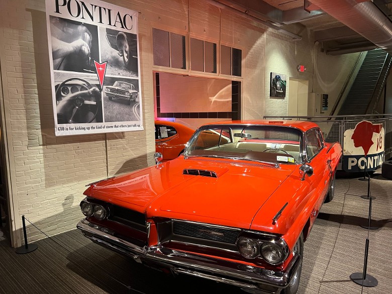 a red Pontiac car on display inside a museum