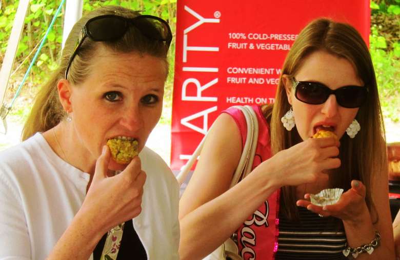 two women taking bites of food