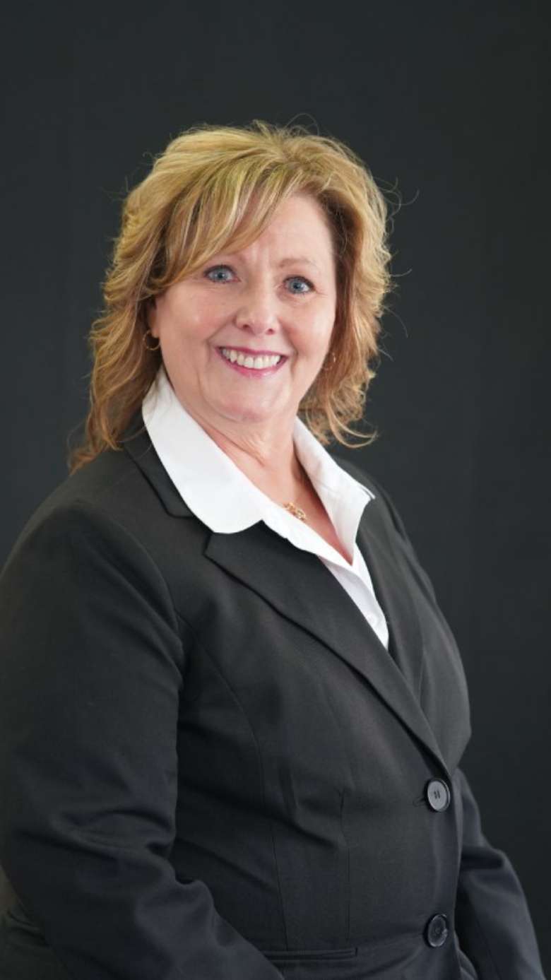headshot photo of a smiling woman wearing a professional black shirt