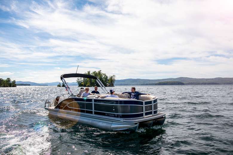 Barletta Pontoon Boat with people smiling while luxury boating on lake george entrace to log bay shelving rock bay