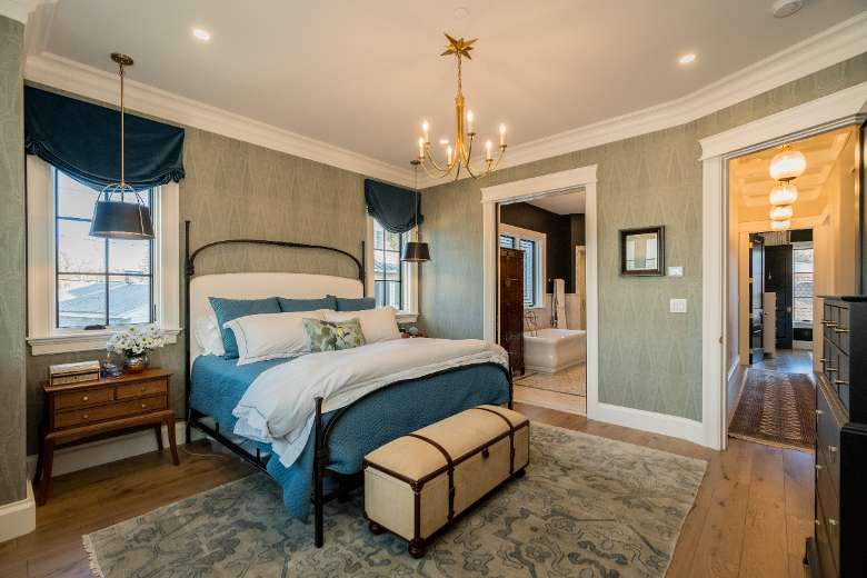 a master bedroom with chandelier and pocket door to the master bath