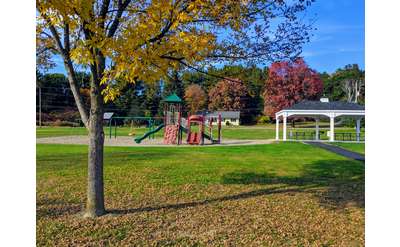 playground and picnic tables under gazebo structure in fall