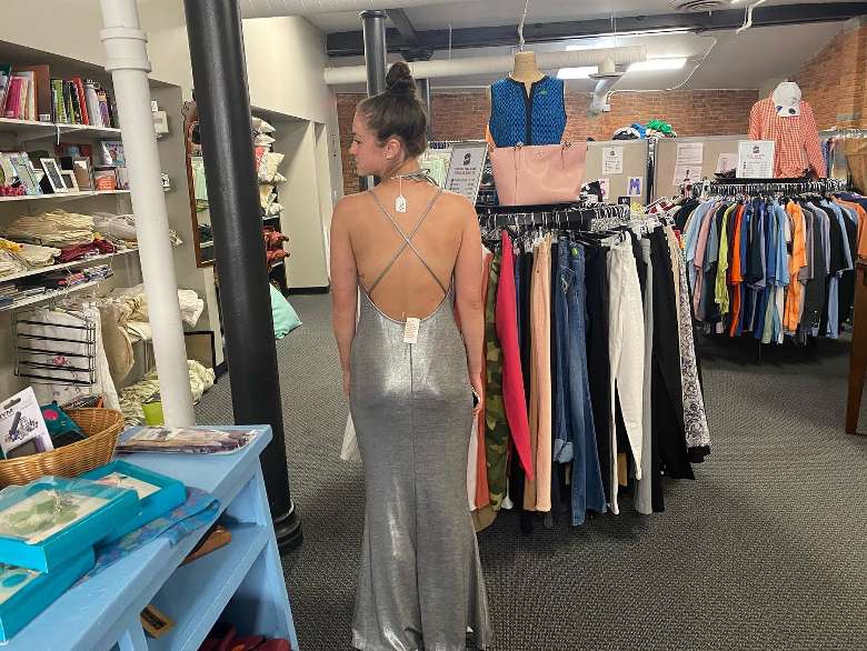 young woman tries on dress in store