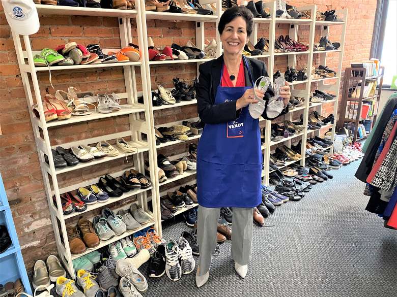 woman in store holds up shoes