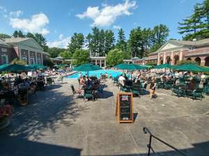 people at tables around an outdoor pool