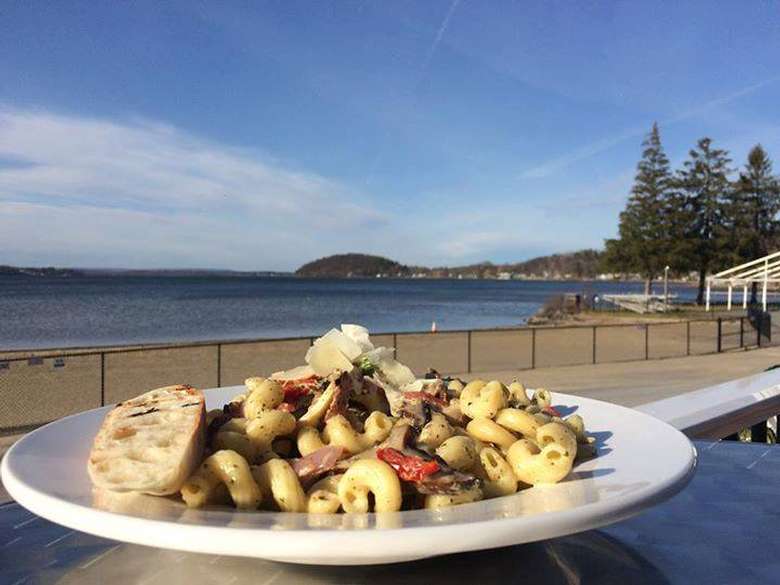 a pasta dish on a table by the lake