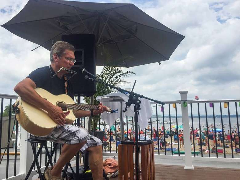 a man playing guitar on the deck