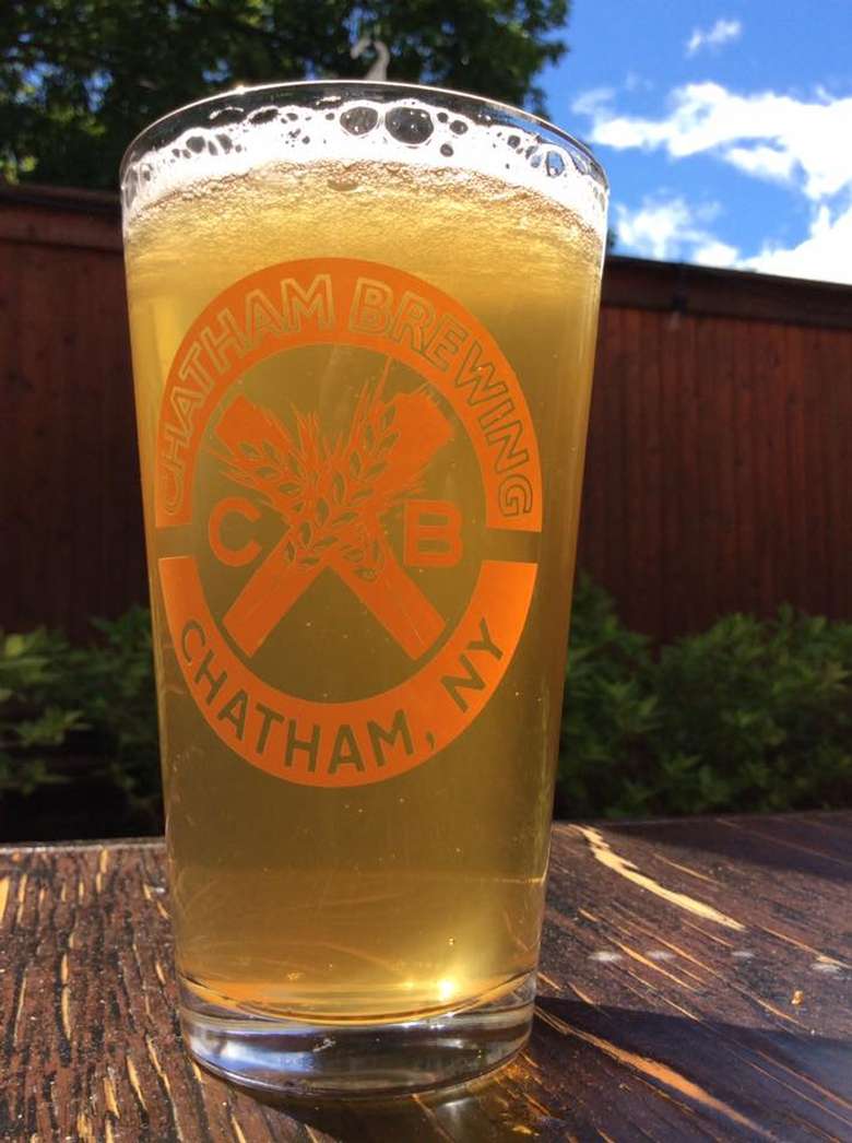 a glass of beer outside with Chatham Brewery logo