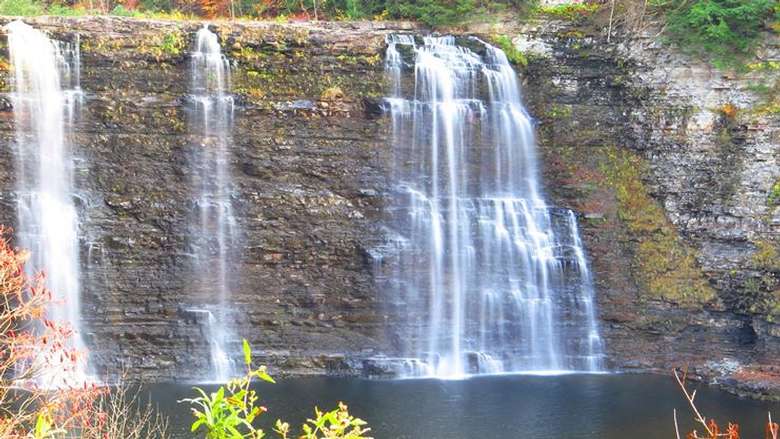 multiple waterfalls flowing down a steep rock face