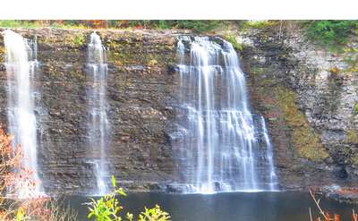 multiple waterfalls flowing down a steep rock face