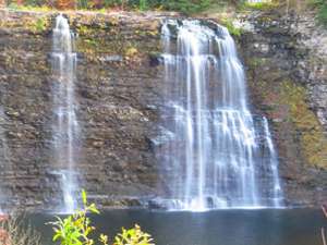 multiple waterfalls flowing down a steep rock face