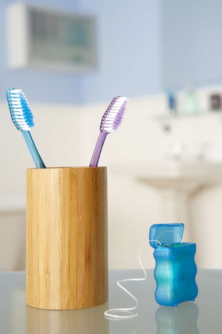 two toothbrushes and a container of dental floss