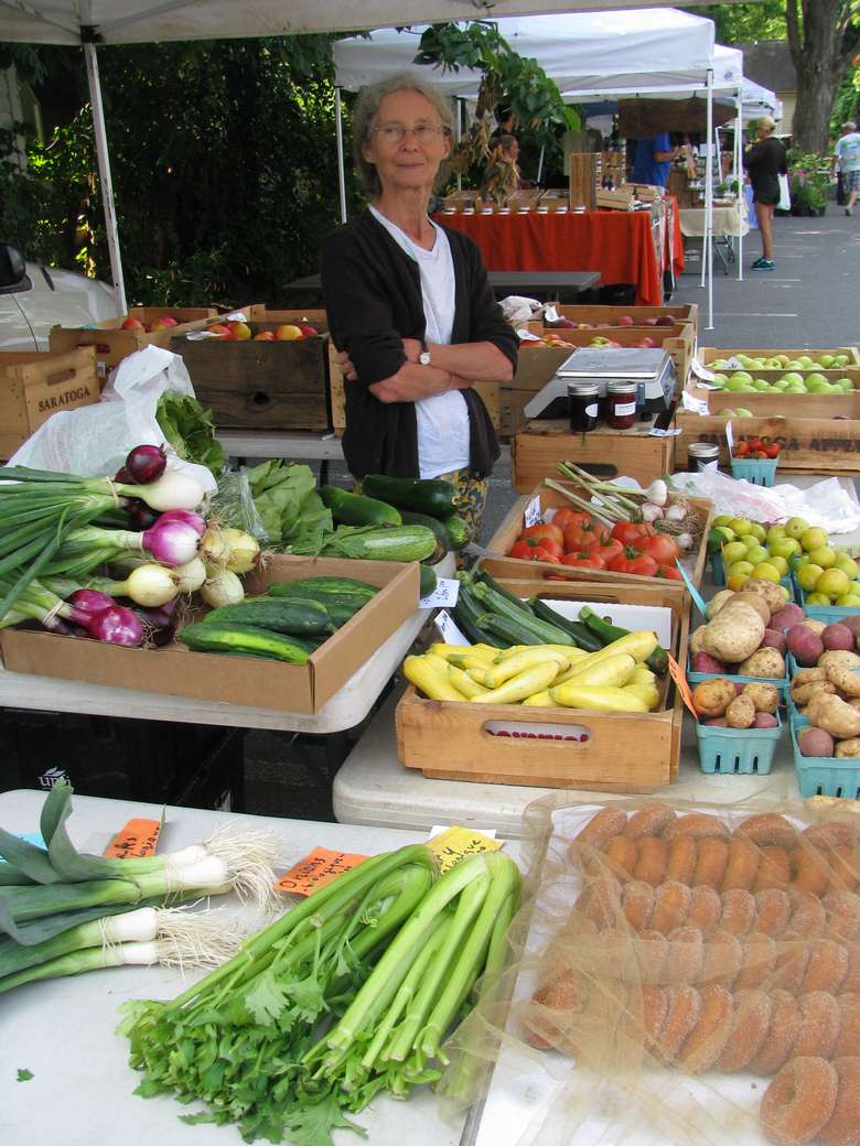 a woman at a vendor booth with produce