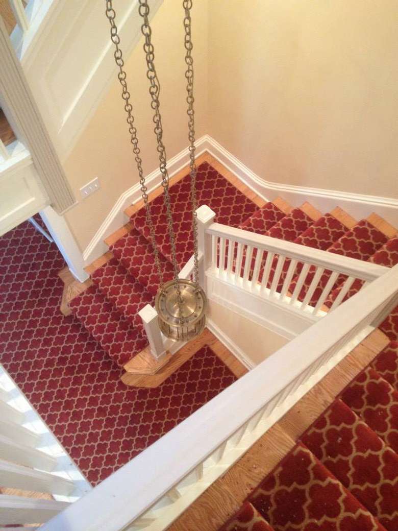 a stairway with multiple corners and red carpeting
