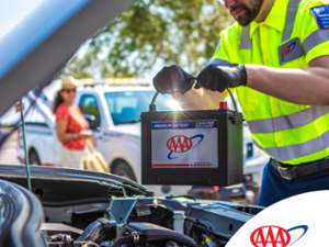 Image of male Triple A Fleet Driver replacing member's vehicle battery with a premium Triple A batter, member smiling as she looks on in background