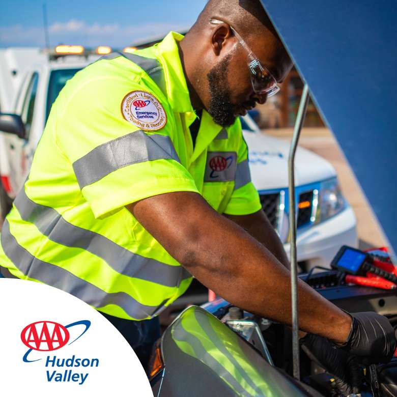 Image of male Triple A Fleet Driver performing a car battery test under vehicle hood