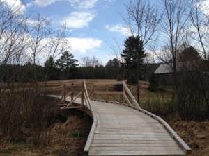 handicap-accessible wooden bridge crossing a creek