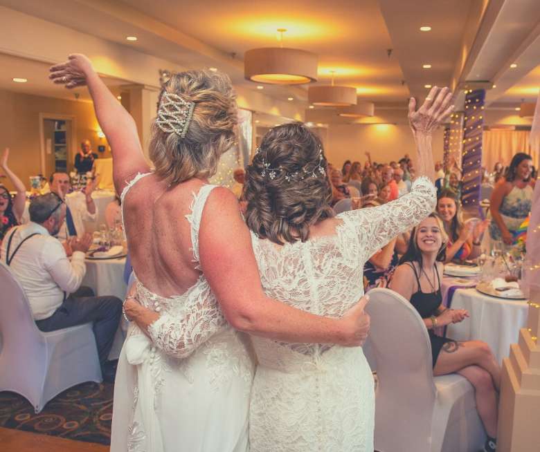 two women in wedding dresses making an entrance