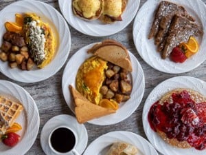 spread of different breakfast foods on plates