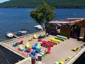 aerial view of a rooftop deck with colorful chairs and tables overlooking lake george