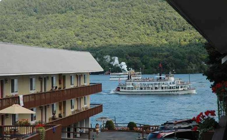 view of a steamboat on lake george with a motel on the left side