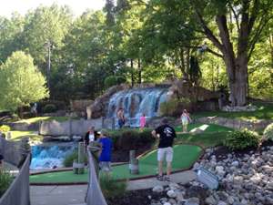 waterfall with people playing mini golf