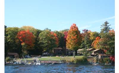 view of cottages from the water, fall foliage on trees