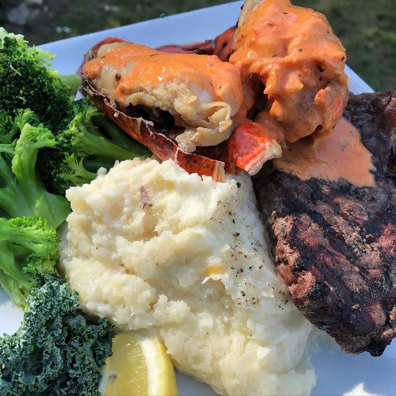 steak with lobster and mashed potatoes and broccoli