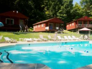 cottage resort property with red cottages and an outdoor pool
