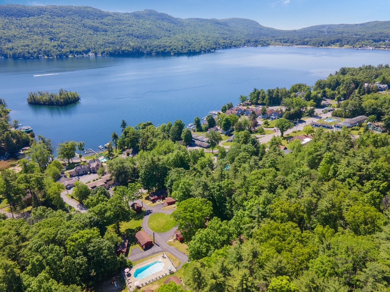 aerial view of lodging properties in wooded area by a lake