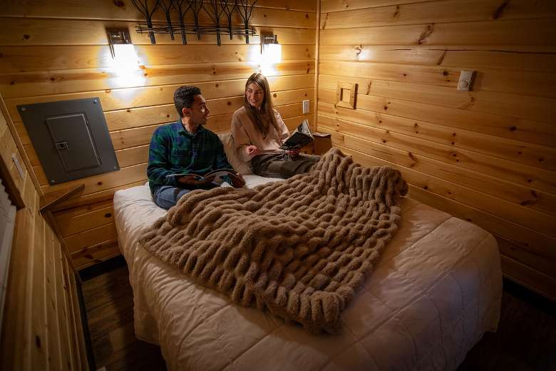 Two guests in the master bedroom of a cabin rental