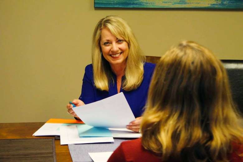 a woman smiling at a client across the desk
