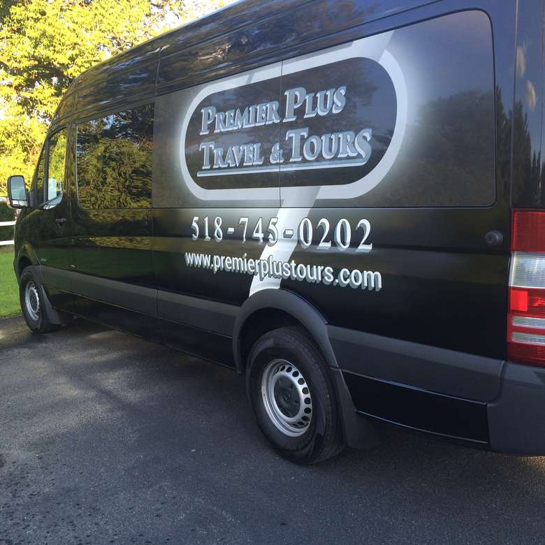 premier plus travel and tours logo on the side of a black van