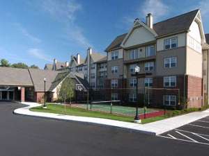 exterior of the residence inn by marriott saratoga springs with a tennis and basketball court visible next to the hotel