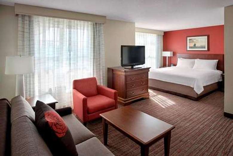 studio suite hotel room with a king-sized bed and a seating area