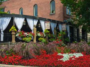 Forno Bistro's exterior with an outdoor covered patio and blooming flowers