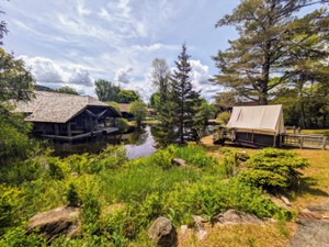 cabin structures and pond at adirondack experience