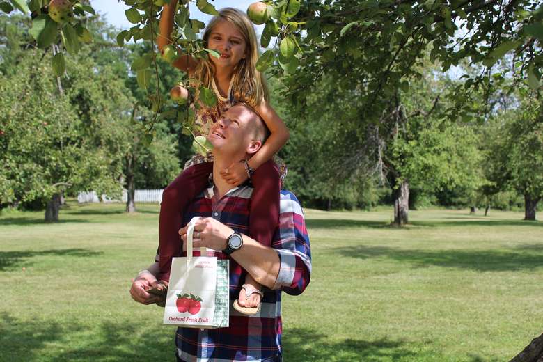 man with young girl apple picking