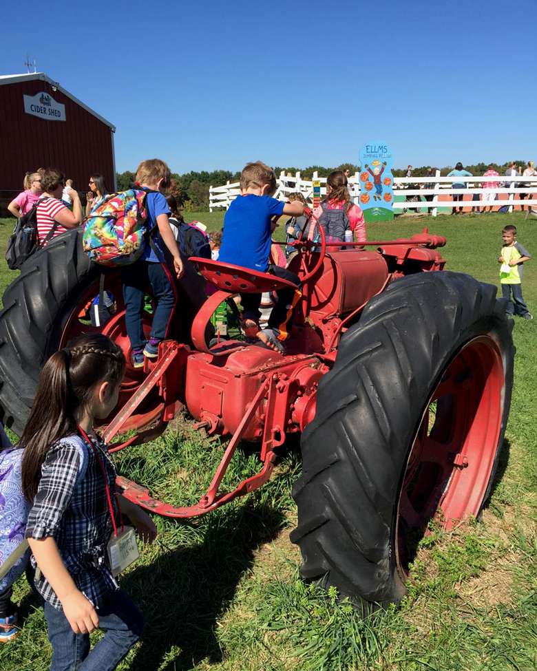 kids pretending to drive a large red tractor
