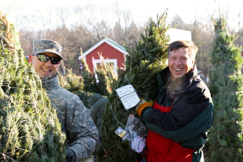 two men posing with christmas trees