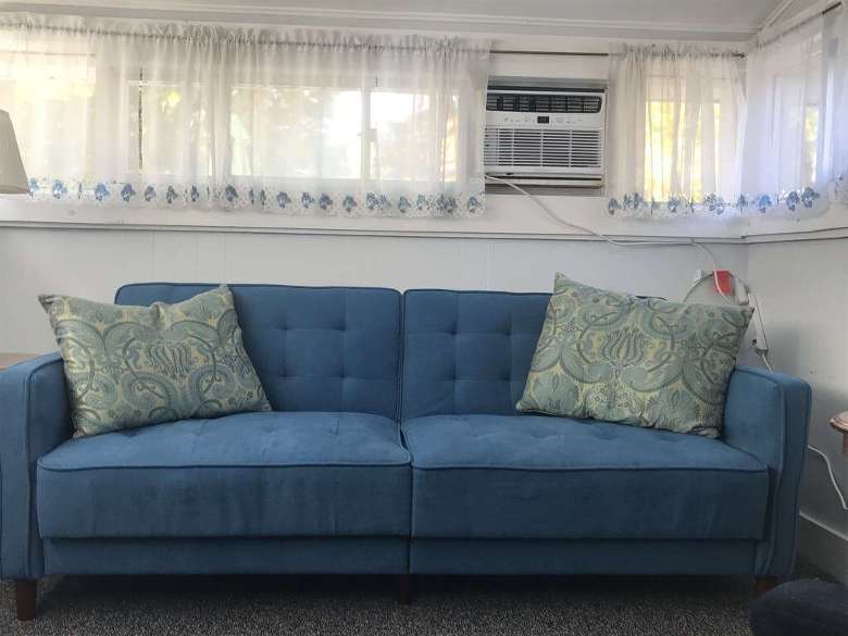 A blue couch in front of windows