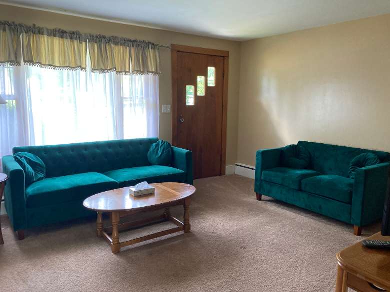 living room with green couches and a wooden table