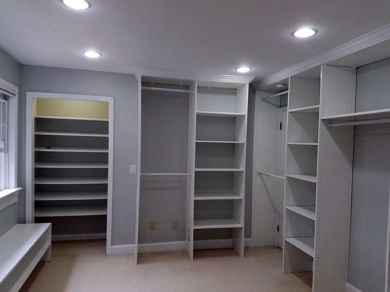 A master bedroom closet with an organization system featuring lots of shelves