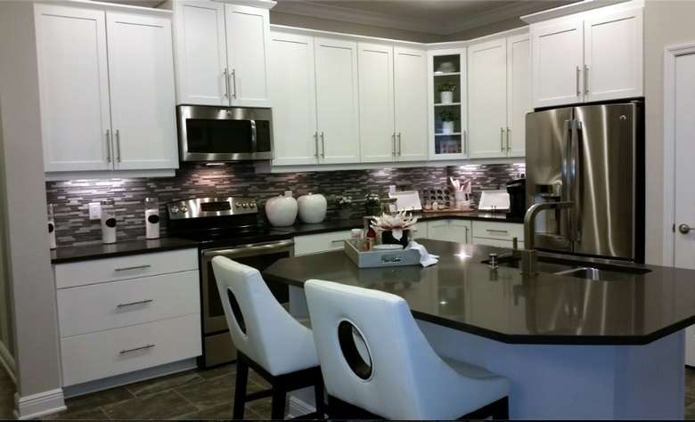 Modern kitchen with white cabinets and stone countertops.