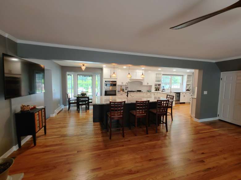 an open dining room and kitchen space with wooden floors