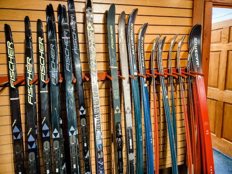 row of skis next to wall with ski equipment